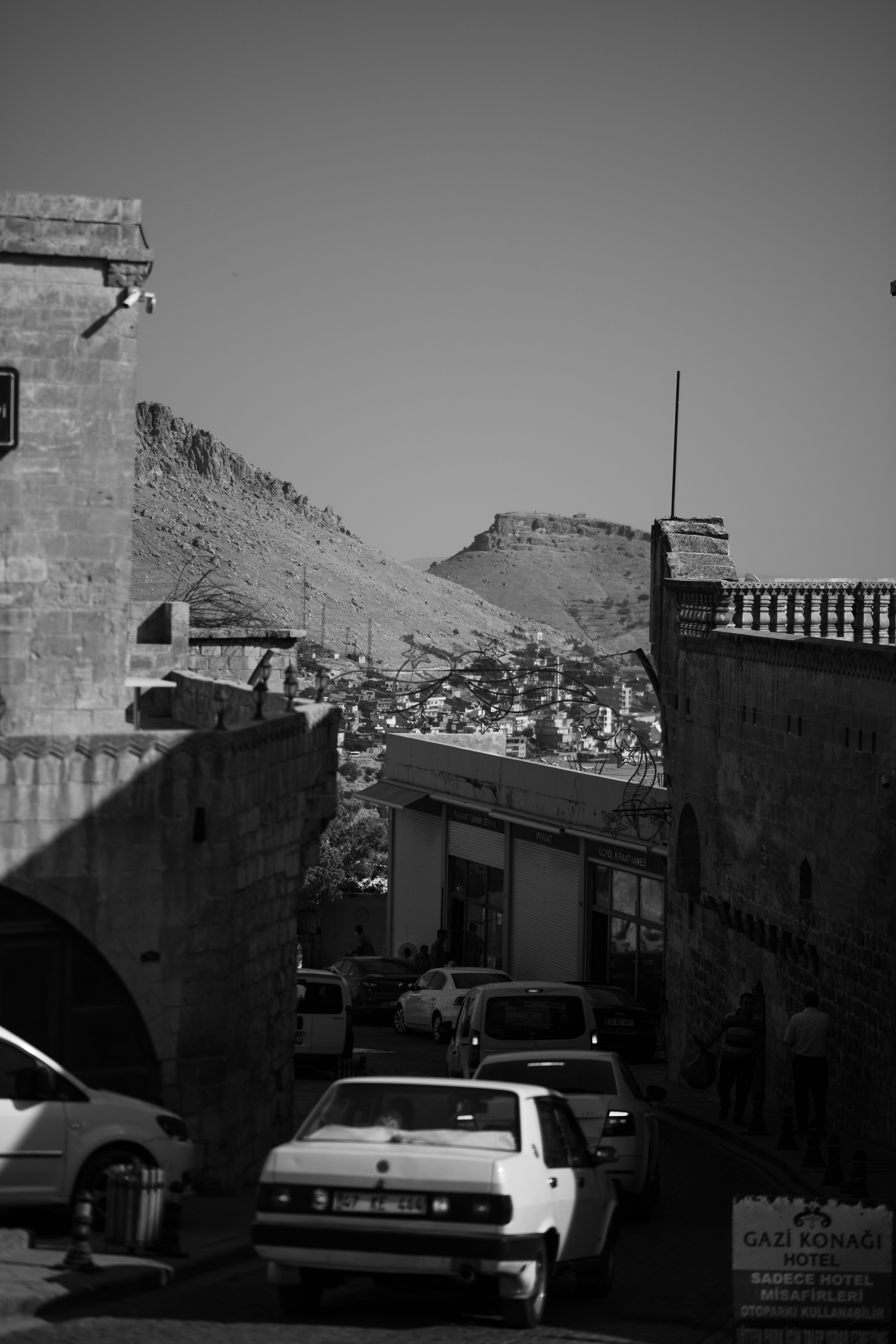 grayscale photo of cars parked beside building